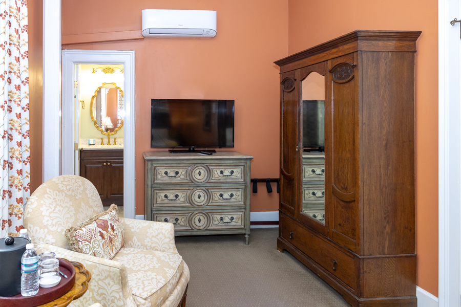 a room with a television and a dresser
