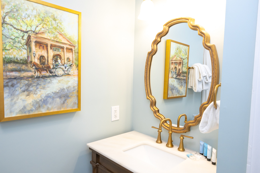 a bathroom with a mirror and a painting
