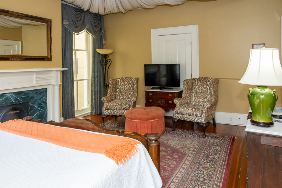 a bedroom with a tv and chairs
